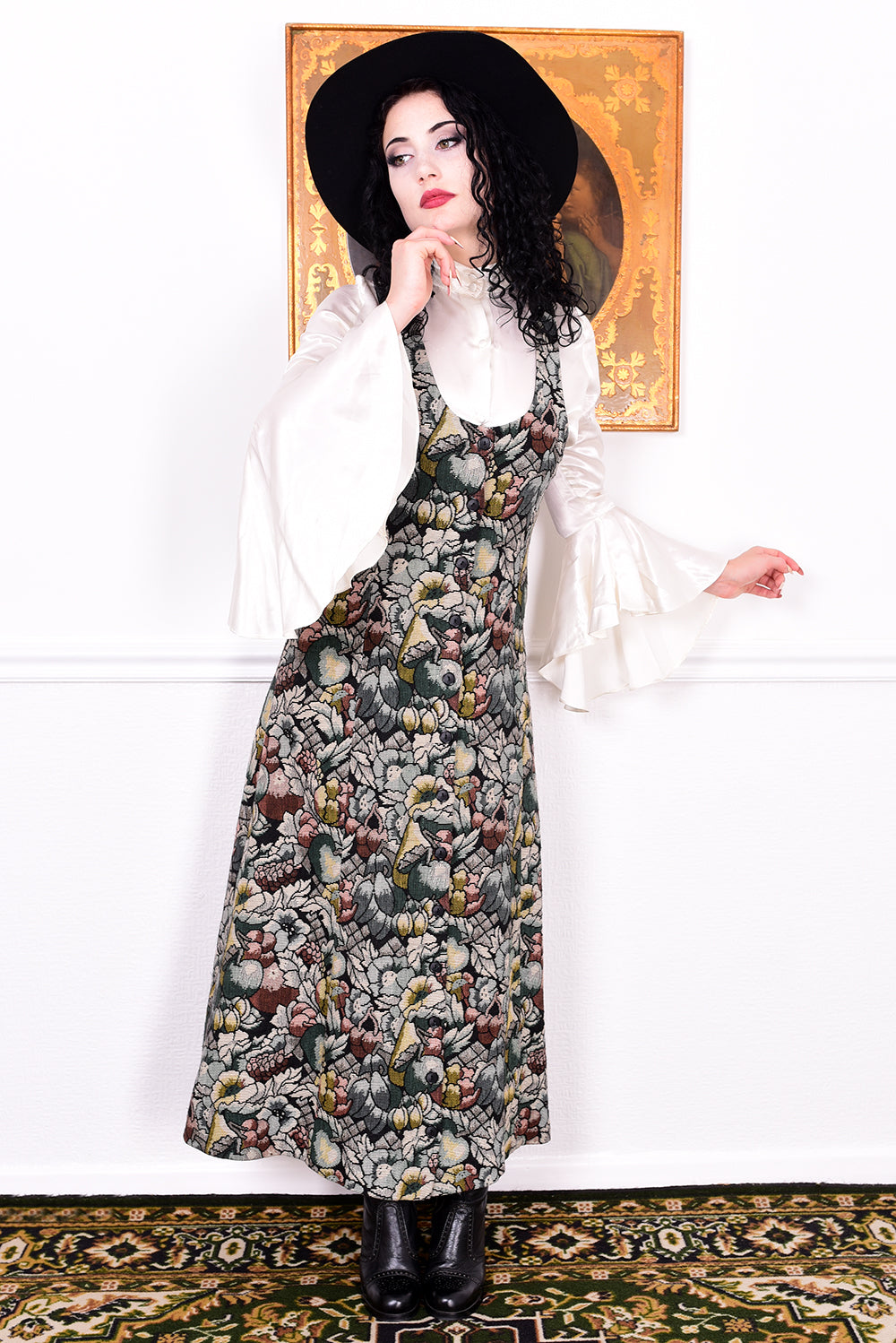 Woman wearing a vintage 1970s floral tapestry dress by Marion Donaldson and black hat.