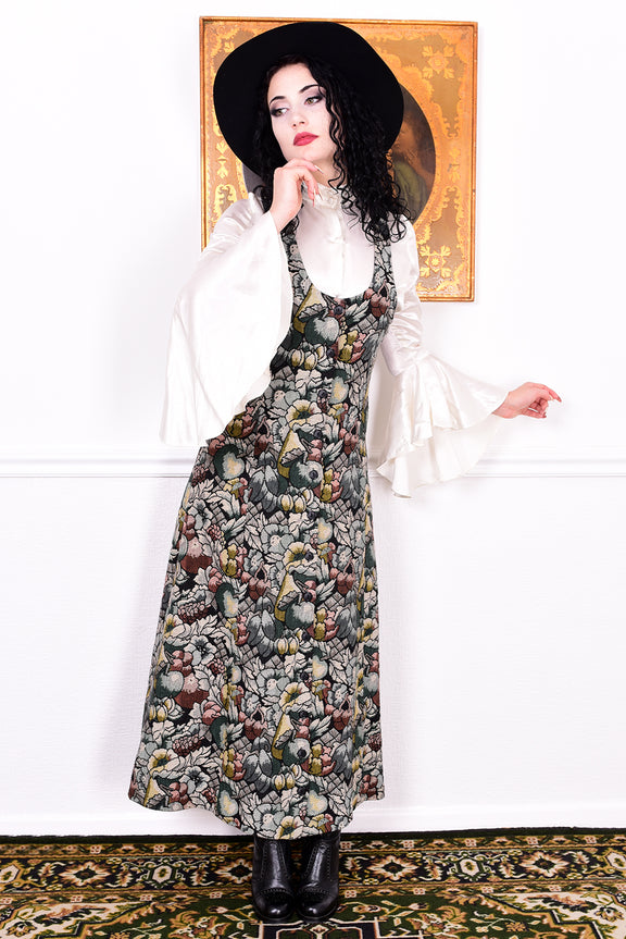 Woman wearing a vintage 1970s floral tapestry dress by Marion Donaldson and black hat.