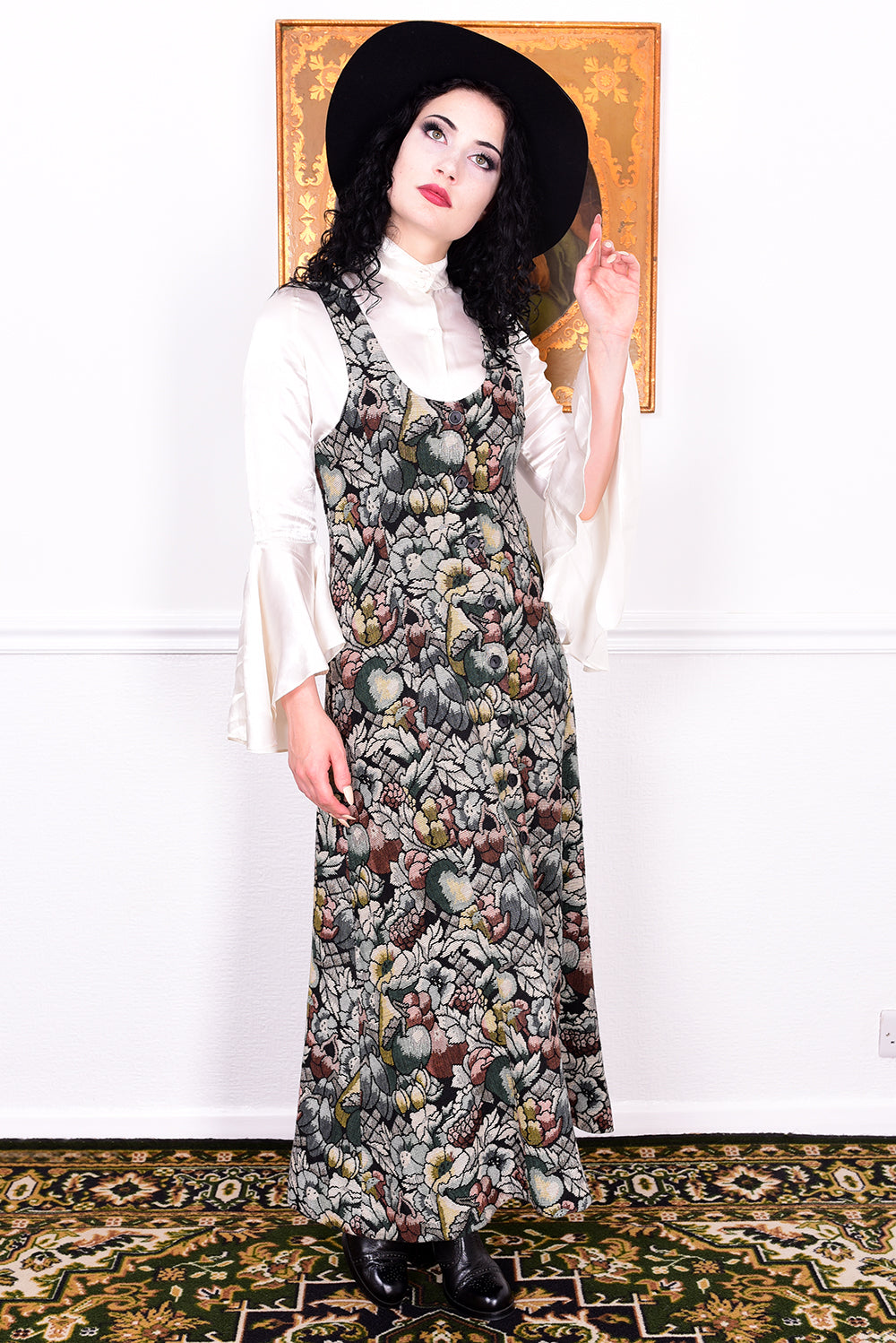 Woman wearing a vintage 1970s floral tapestry dress by Marion Donaldson and black hat.