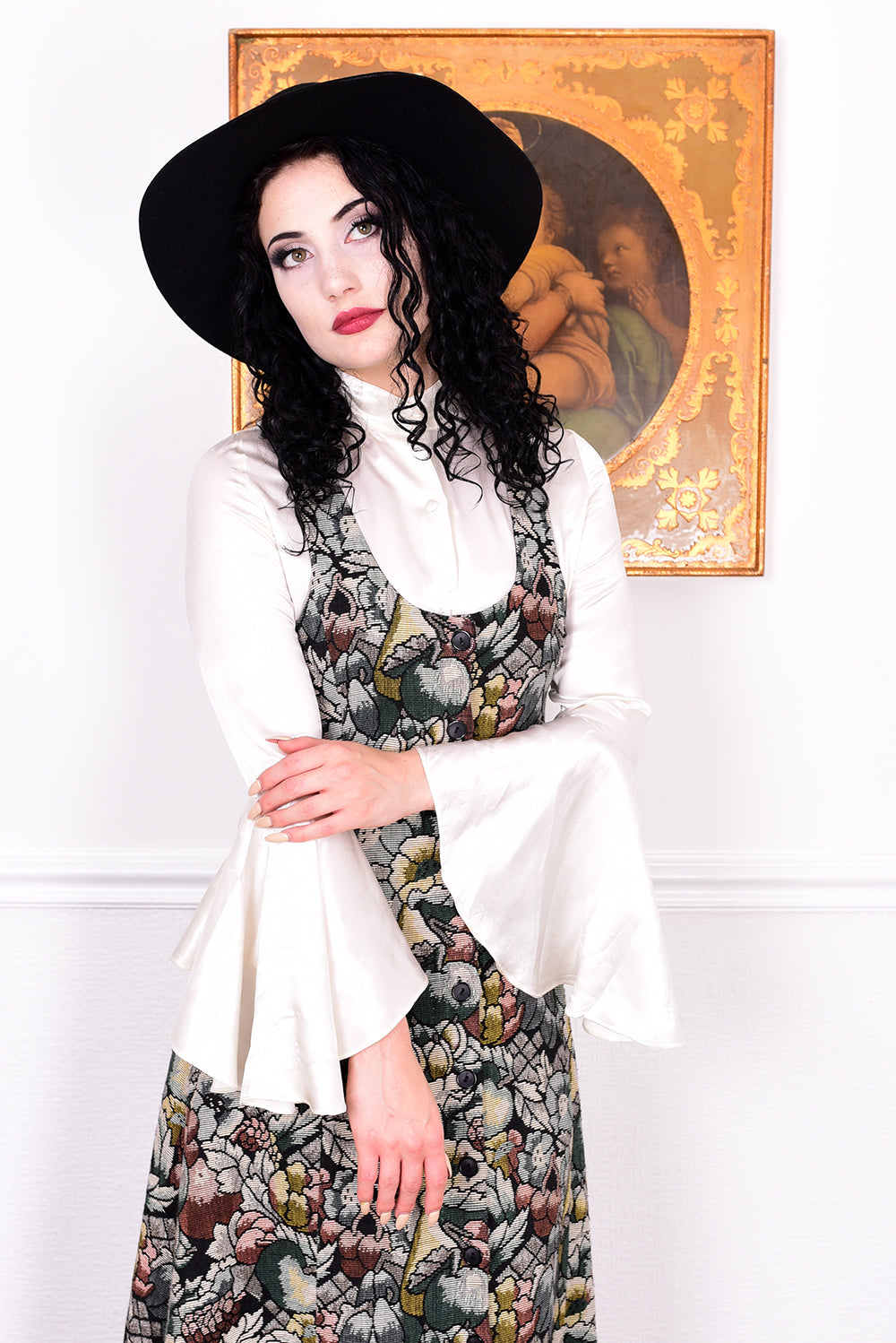 Woman wearing a vintage 1970s floral tapestry dress by Marion Donaldson and black hat.
