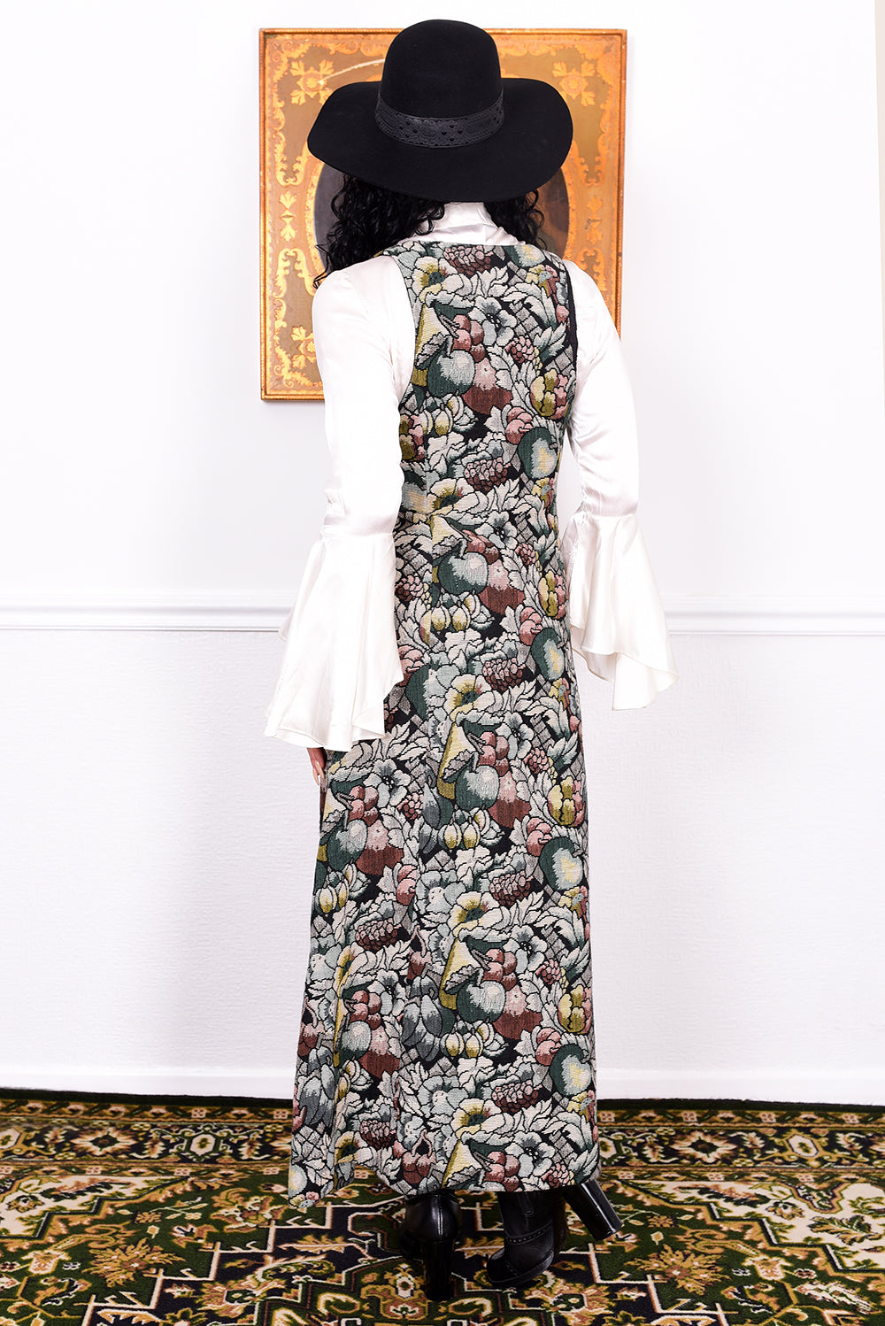 Woman wearing a vintage 1970s floral tapestry dress by Marion Donaldson and black hat.