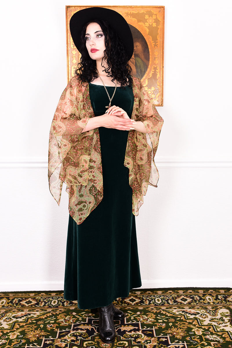 Woman in a vintage 1970s emerald green velvet dress with floaty floral print sleeves by Quad.