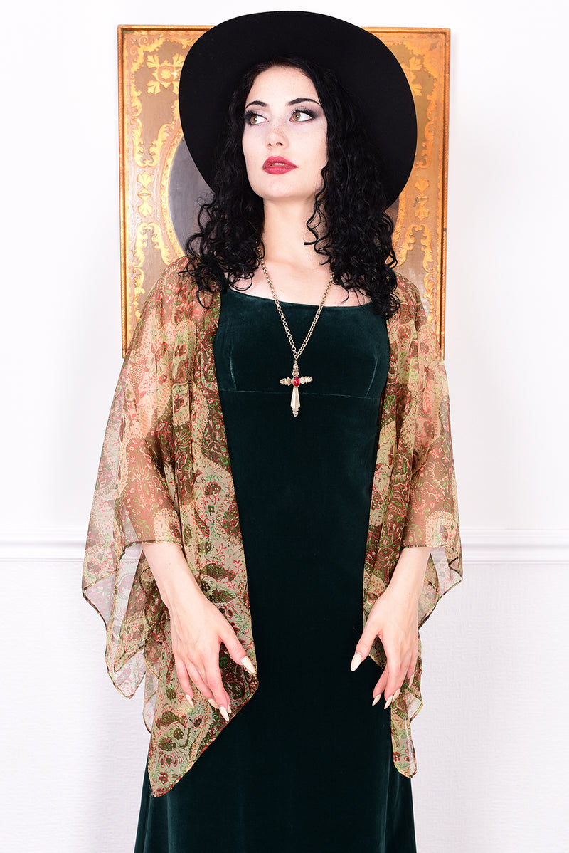 Woman in a vintage 1970s emerald green velvet dress with floaty floral print sleeves by Quad.