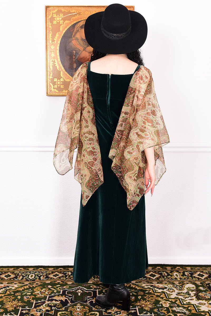 Woman in a vintage 1970s emerald green velvet dress with floaty floral print sleeves by Quad.