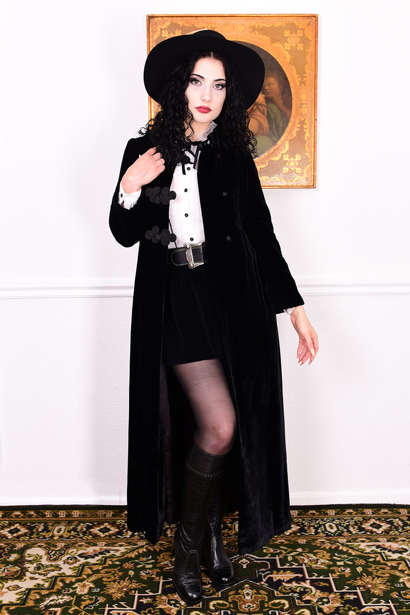 Woman wearing a vintage 1960s long black velvet coat and hat.