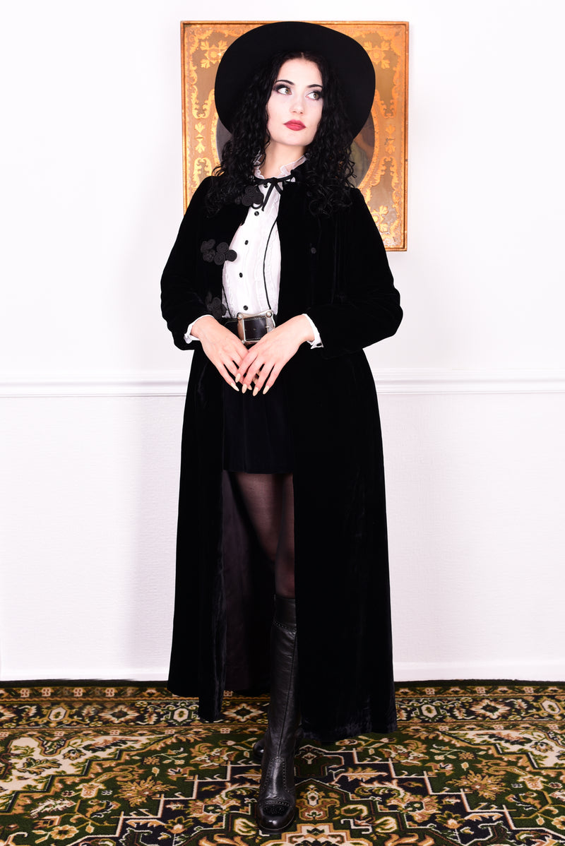 Woman wearing a vintage 1960s long black velvet coat and hat.