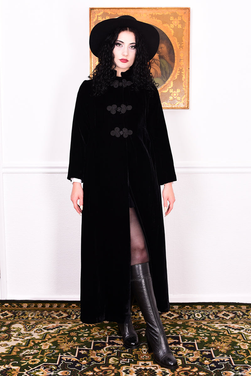 Woman wearing a vintage 1960s long black coat and hat.
