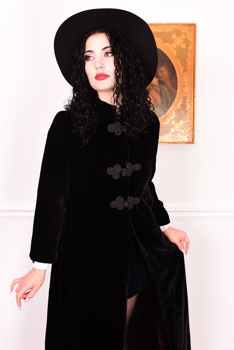 Woman wearing a vintage 1960s long black velvet coat and hat.