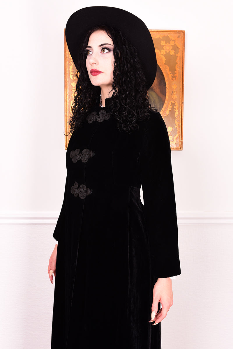 Woman wearing a vintage 1960s long black velvet coat and hat.