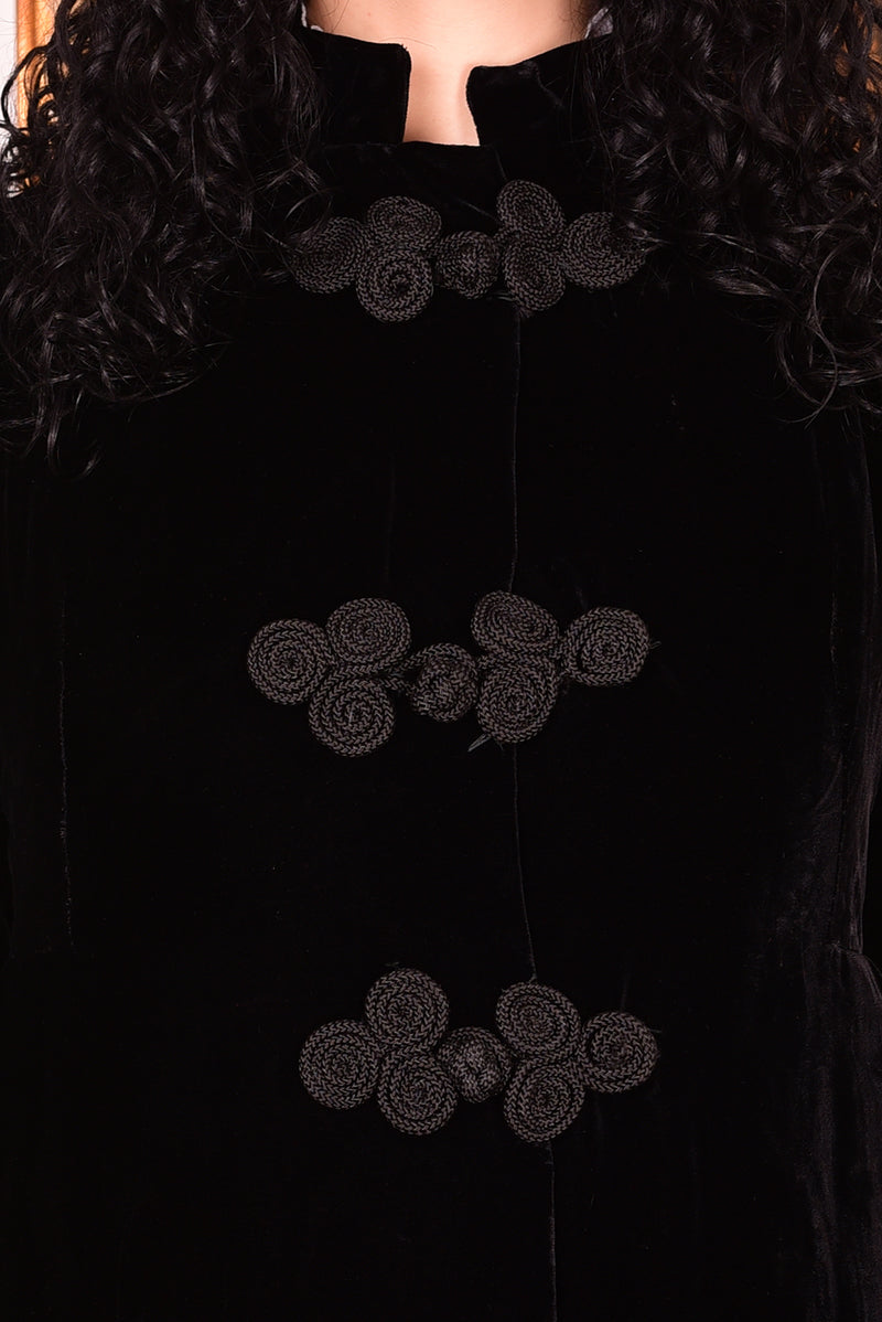 Woman wearing a vintage 1960s long black velvet coat and hat.