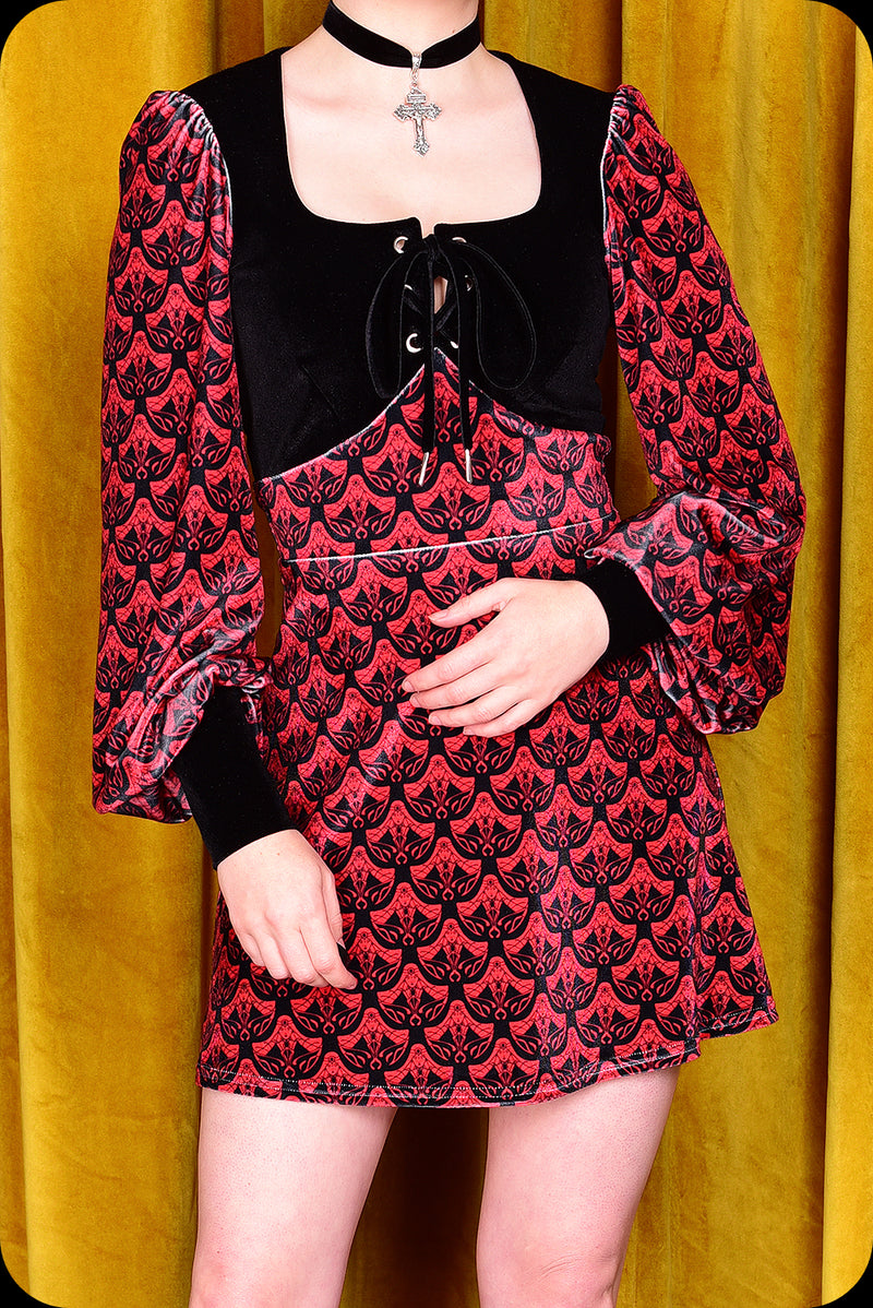 A red logo print velvet Carmilla mini dress by Scorpio Rising