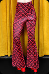 A pair of red logo print velvet bell bottom trousers by Scorpio Rising
