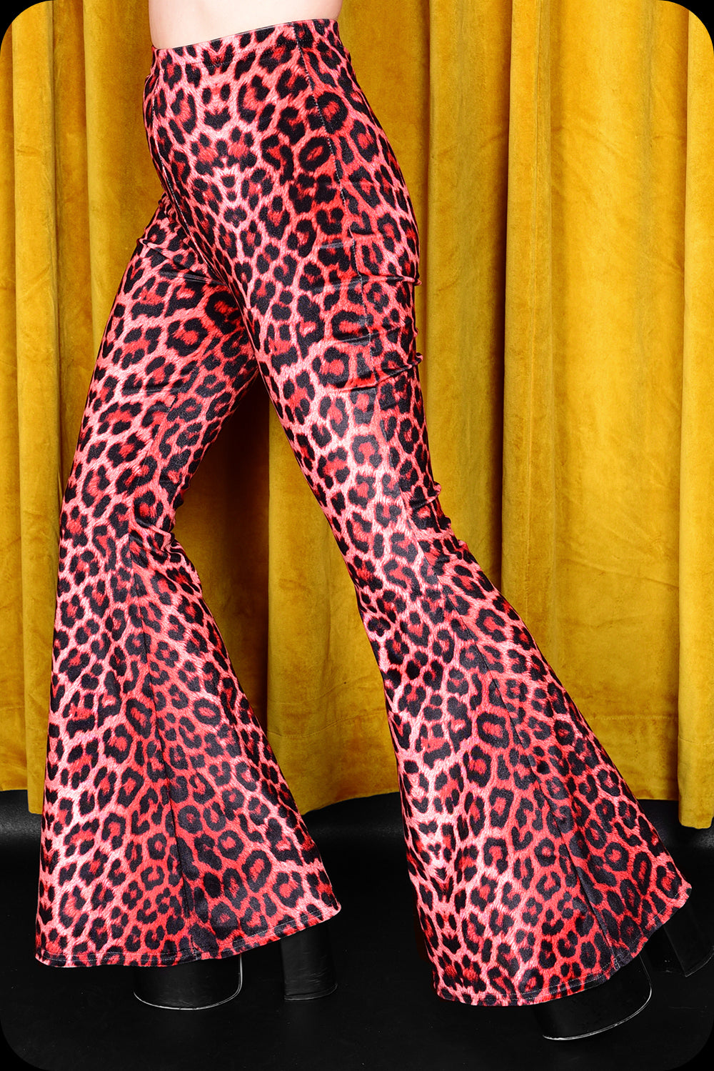 A pair of red leopard print velvet bell bottom trousers by Scorpio Rising